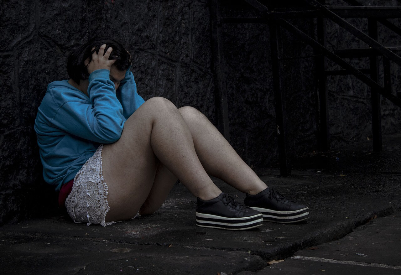 Image of a sad girl sitting on the floor